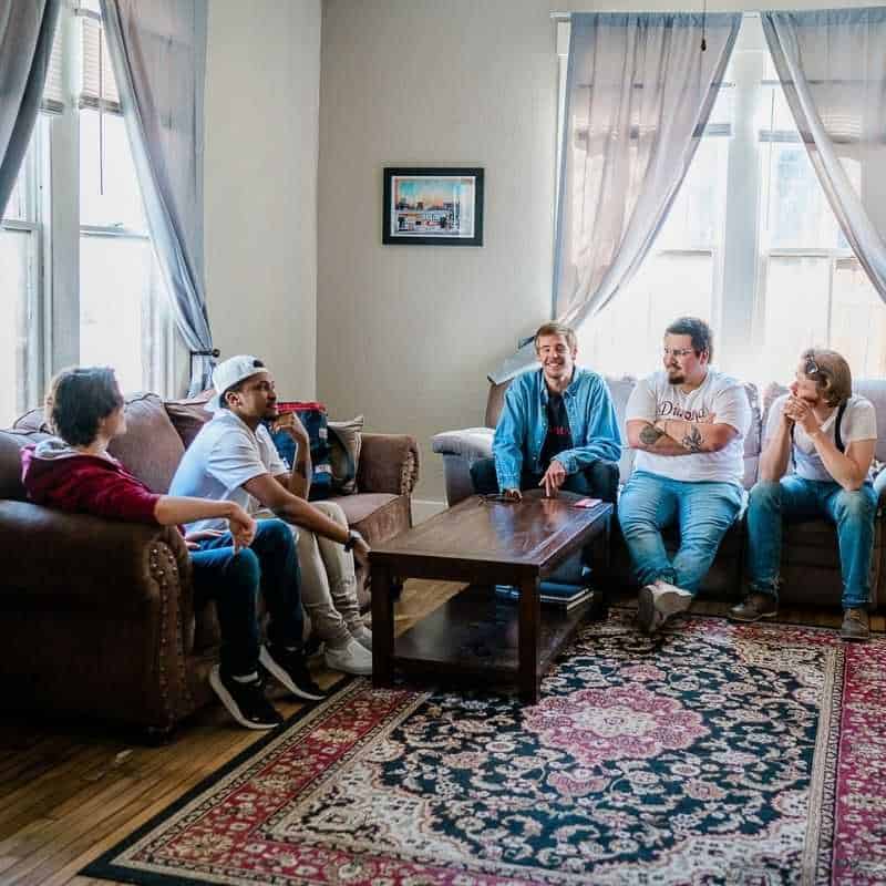 Students in living room of sober living house